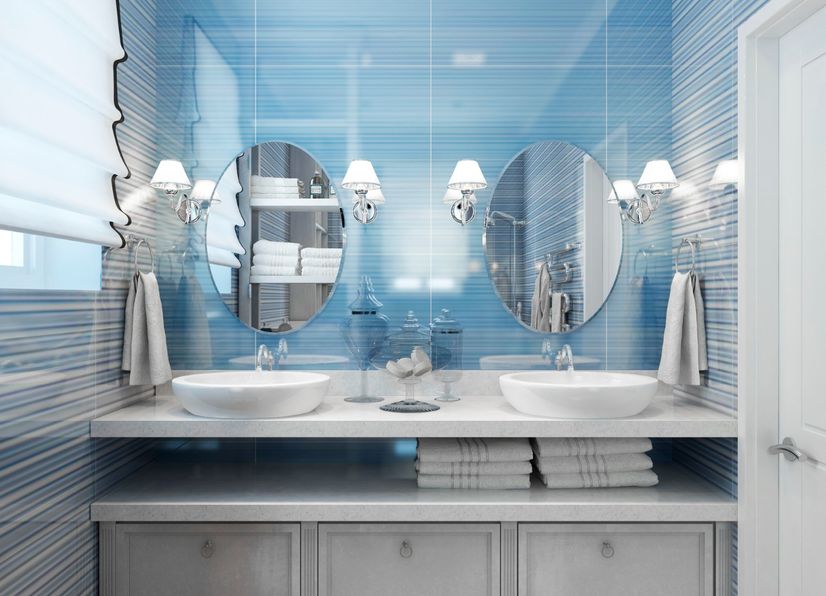 Modern blue bathroom with freestanding tub and
round mirror